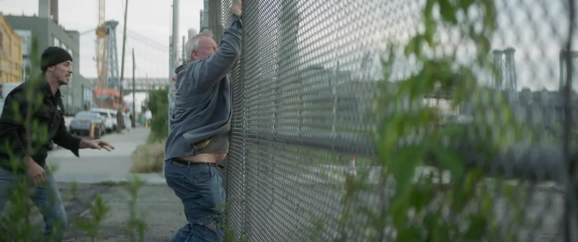 Old man being thrown on fence by a younger man