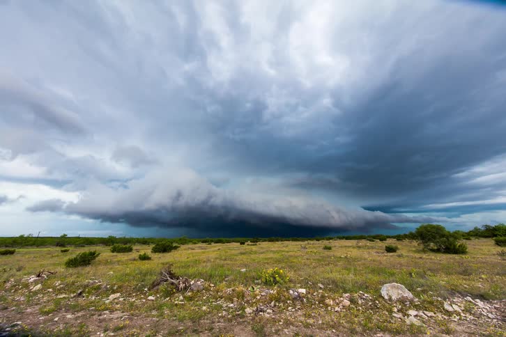 Storm clouds float over an open field