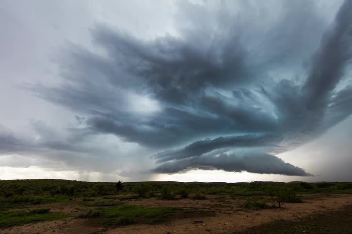 Time lapse of a large field with a storm forming in the distance