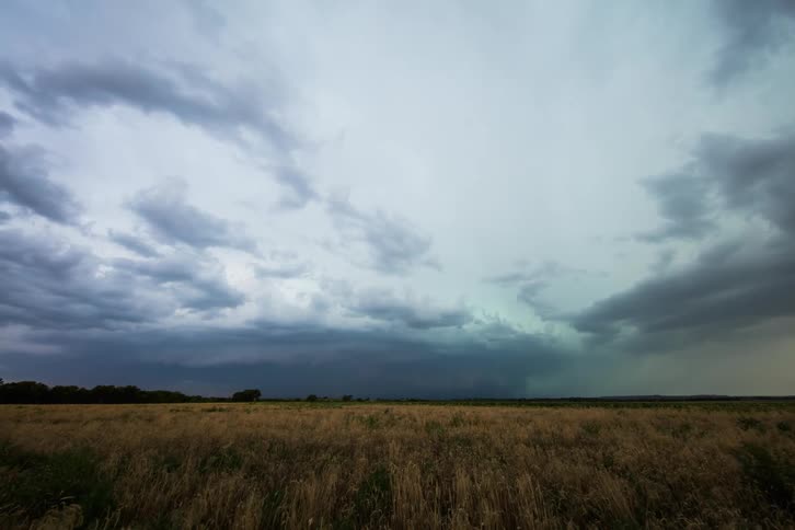 Storm clouds roll in over a field