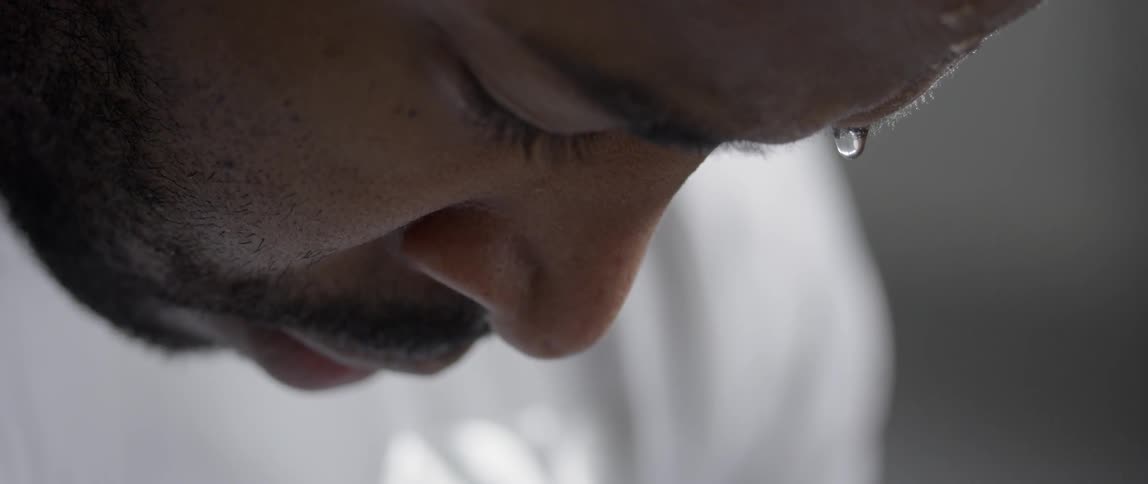 A man is leaning forward sweating