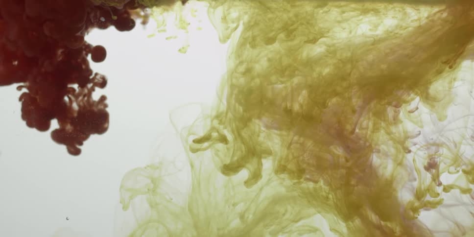 Green and purple substances float down slowly in water