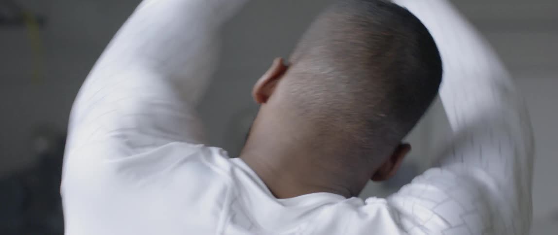 An athlete stretches his arms, neck and shoulders