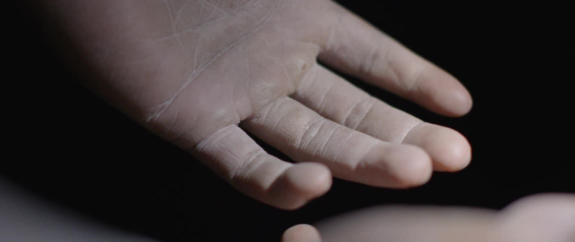 Two hands lower in a dark area