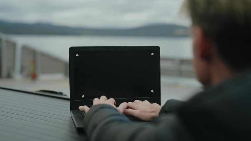 A person types on a laptop keyboard