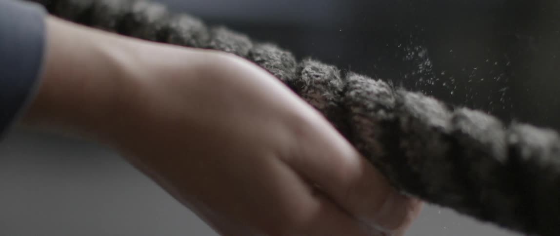 A hand touches a rope