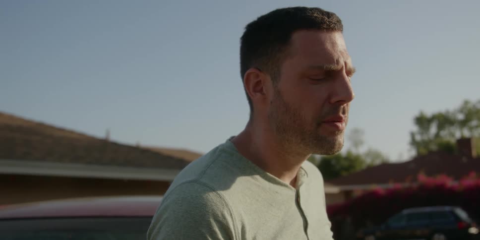 Man standing next to a car smoking a cigarette at daytime