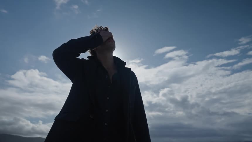 A man is looking around the desert