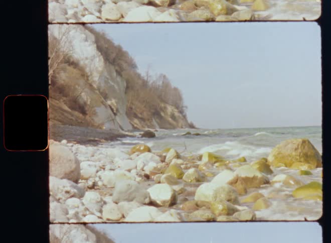 Ocean waves roll into a rocky coastline during the day