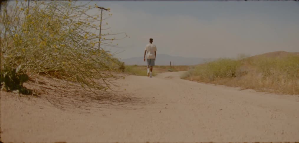 A man walks down the dirt trail