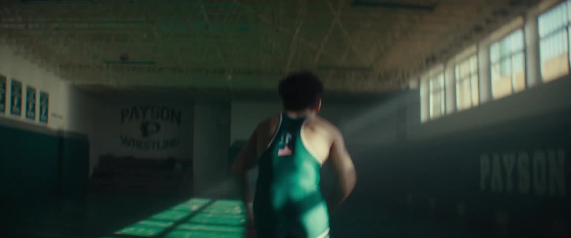 A young man training by running across an empty gymnasium
