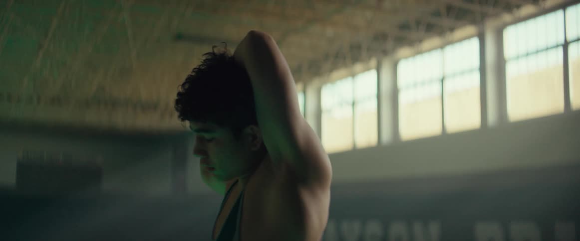 A teenager is stretching in the gym