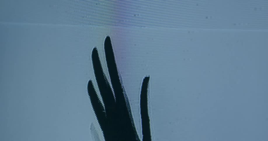 A hand waves on the static filled screen