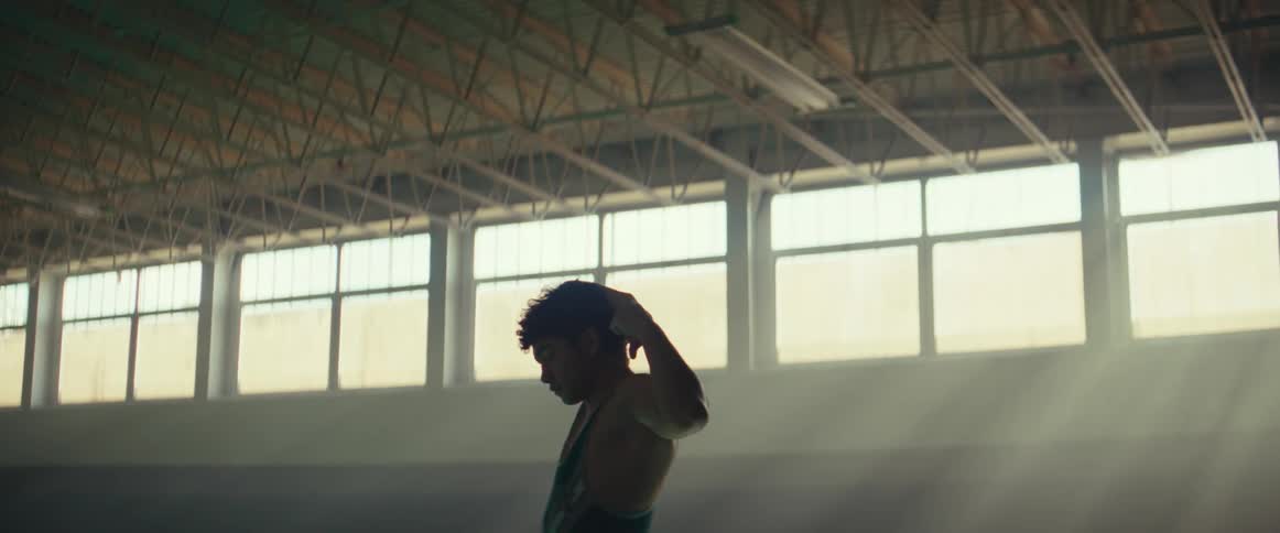 A man stretches his arms over his head while working out