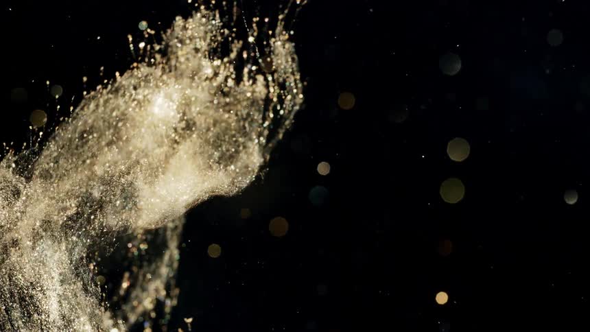 Golden glittery liquid splashes across a back background