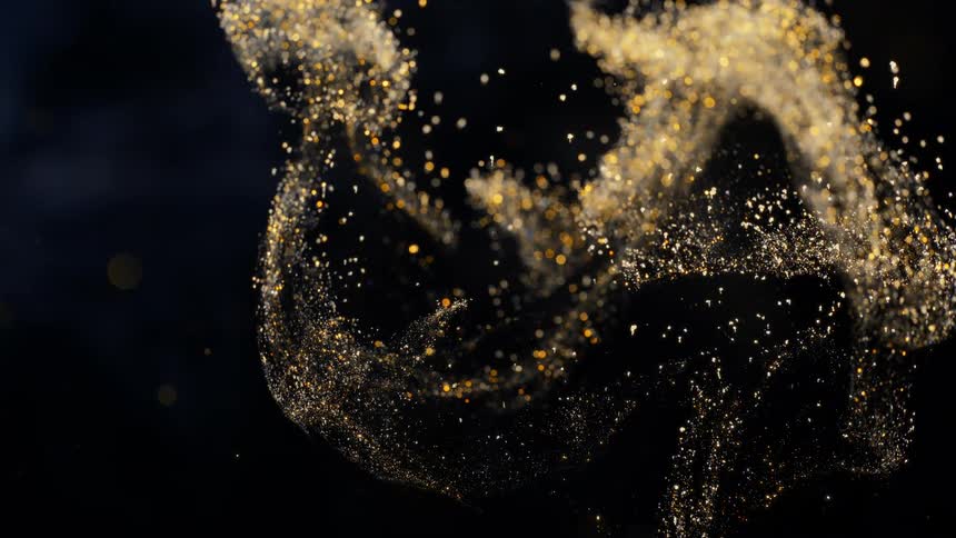 The orange metallic sparkles fly in the air like a magic cloud