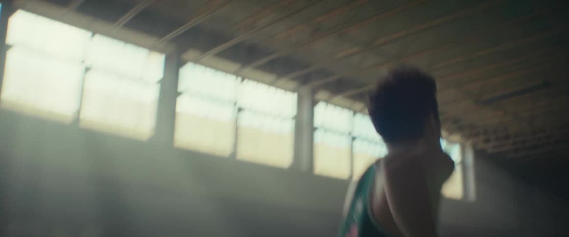 Young man running and training in an empty gymnasium