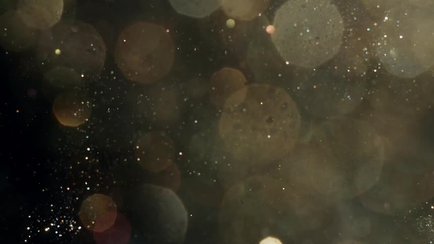 The glitter flies around like particles or dust in a liquid