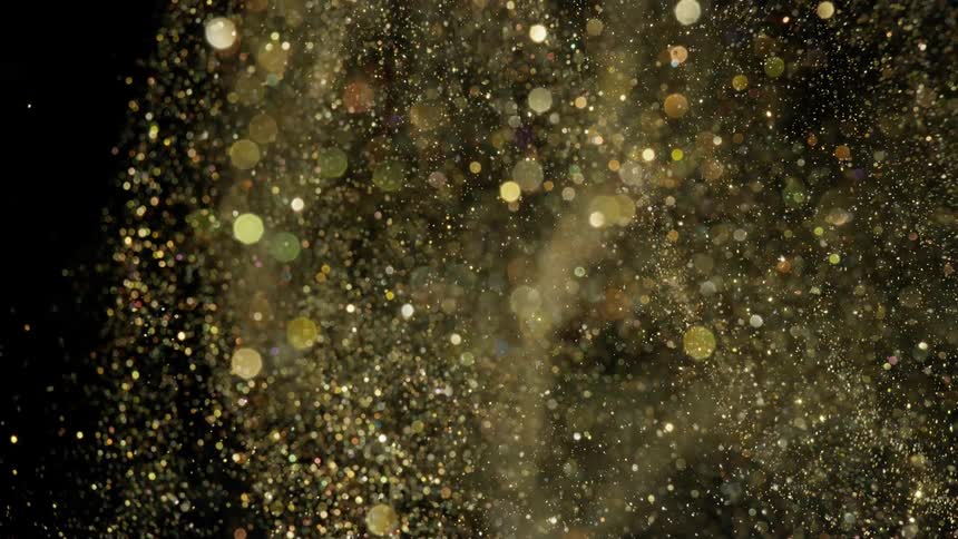 Metallic particles fly through air as light spots contrast with black background