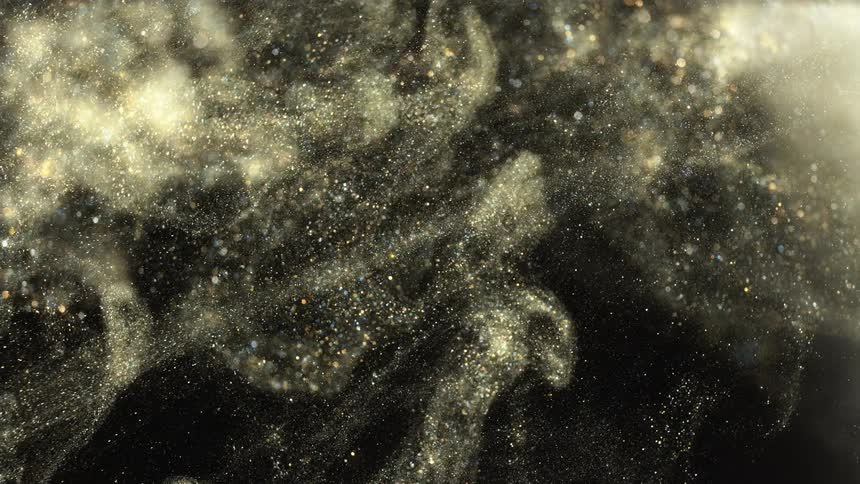Glitter falls against a black background