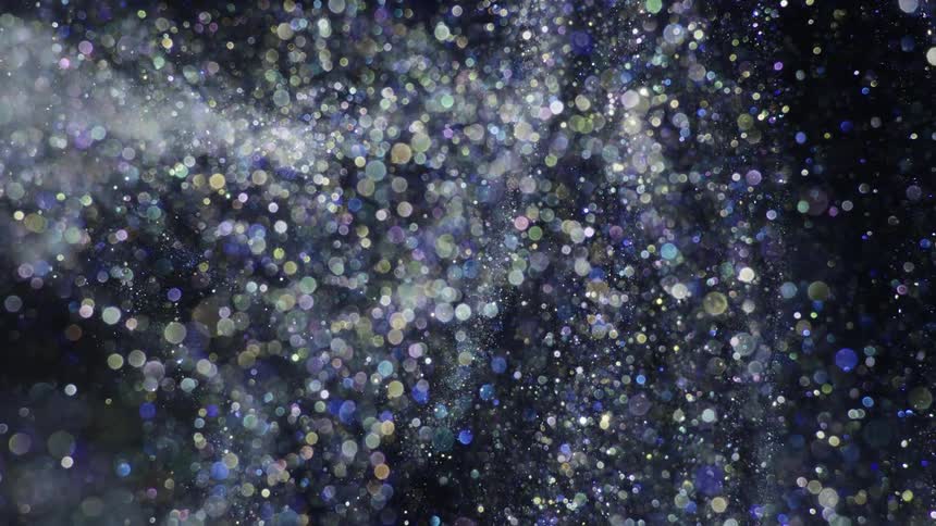 Silver glitter is moving through the air in slow motion