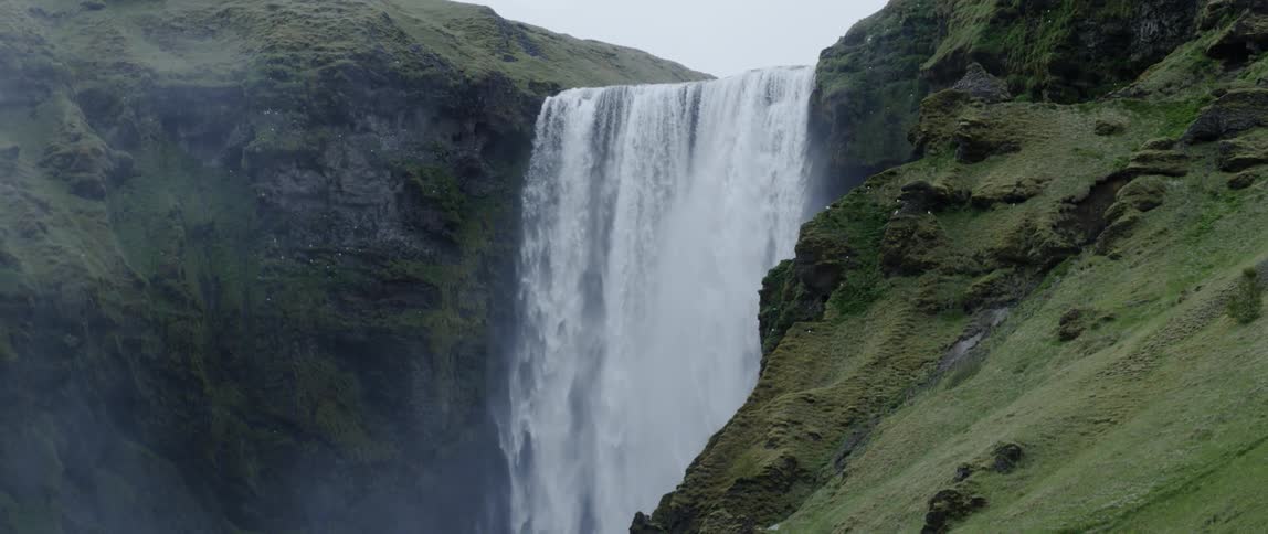 A waterfall flows over a cliff