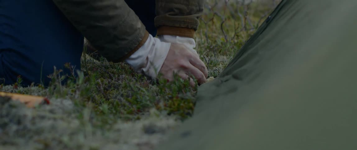 A man is planting something in the grass