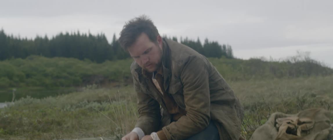 A white man studies and writes on a map