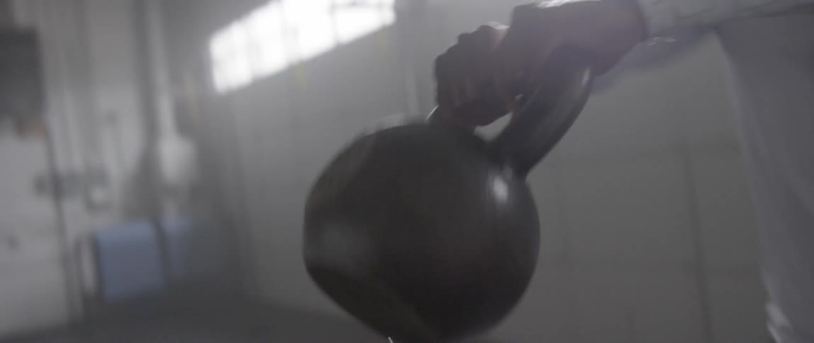 A man is exercising using a kettlebell