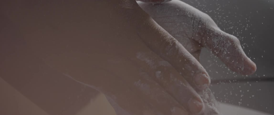 A person is rubbing chalk on the palms of their hands