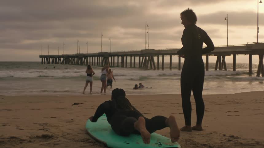 People are practicing surfing on the beach