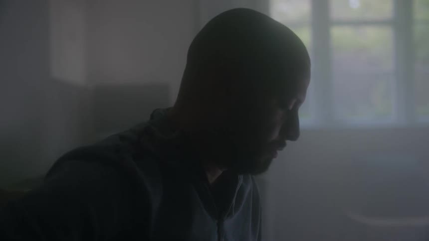 A man is looking down in the foggy room