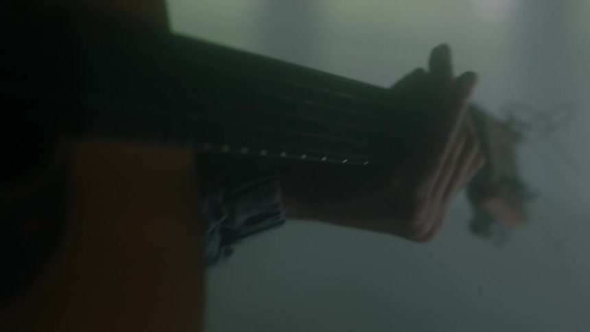 A hand playing a guitar