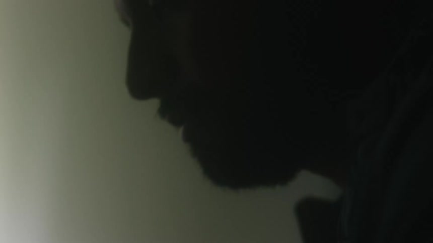 Bearded man using a laptop touching the touchpad