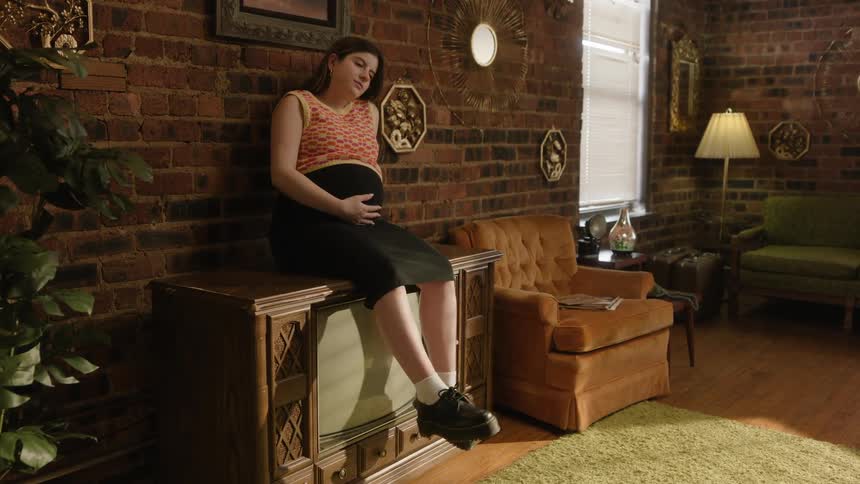 A woman is sitting on the television