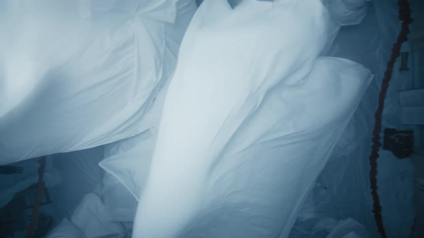 The sheet blows around over someone laying down