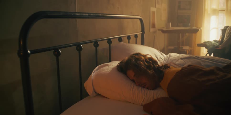 Man sleeping in his bed with sunlight coming through the window