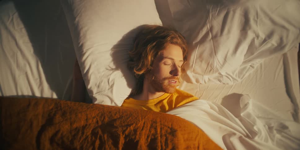 Sheet pulled across bed guides man into turning in his sleep