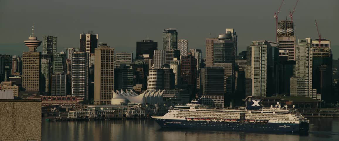 A cruise ship travels along the coast of a metropolis during the day