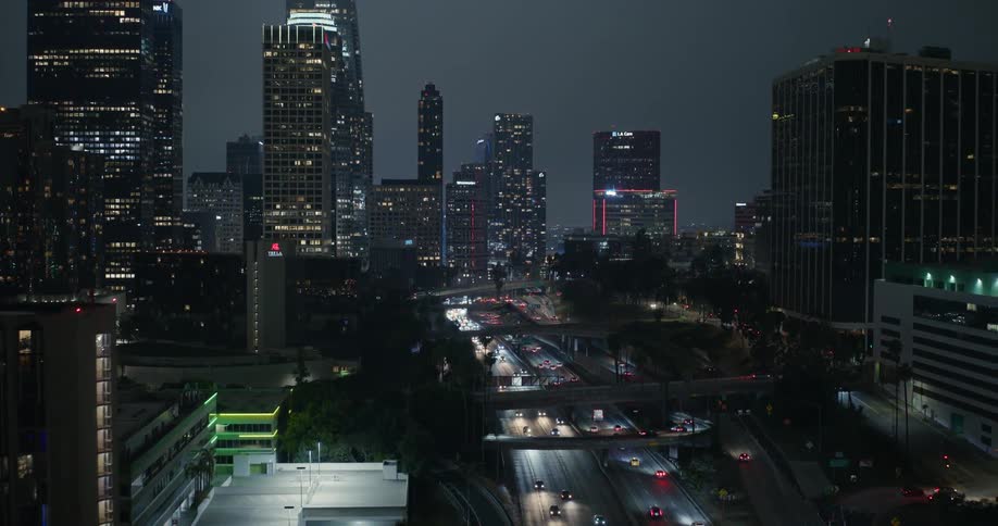 Traffic travels along a freeway through a metropolis at night