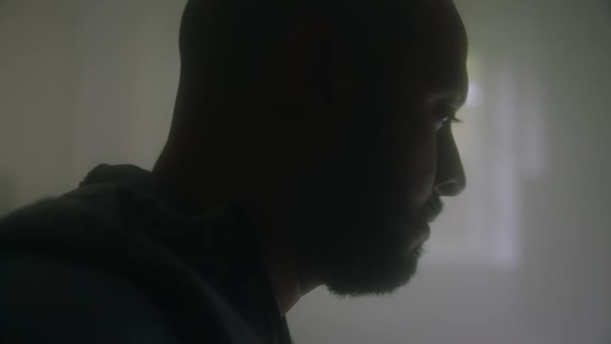 Man sitting in dim room bobs his head while working