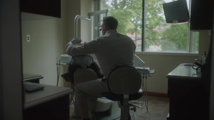 A dentist is examining a patient