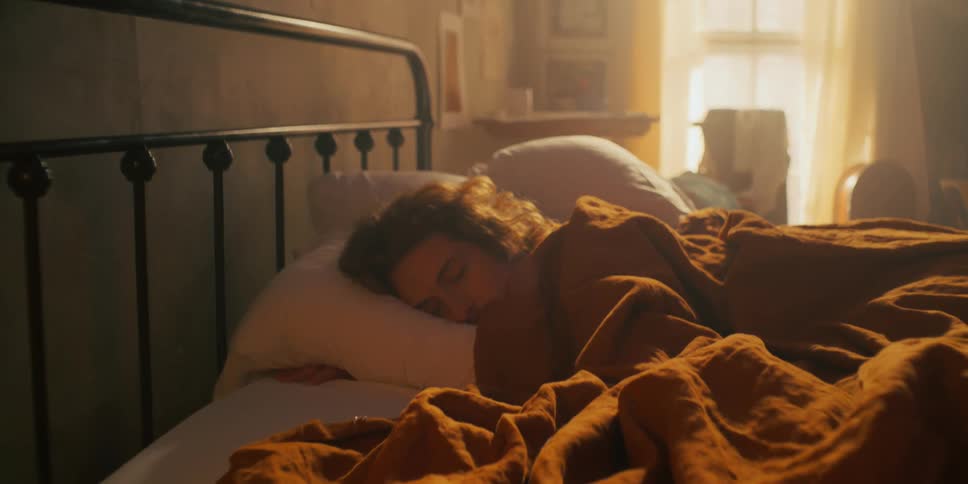 Man lying in bed with a brown blanket warming him