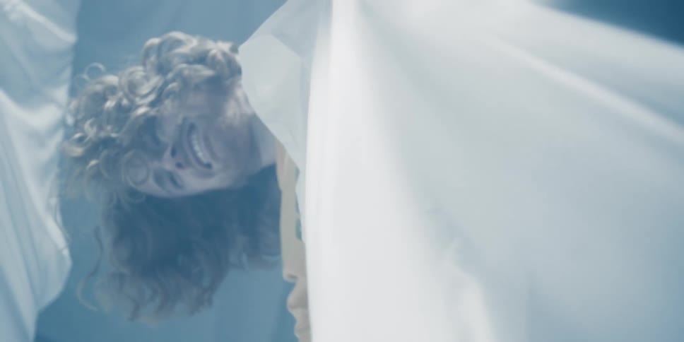 A man pulls at the sheet and falls down