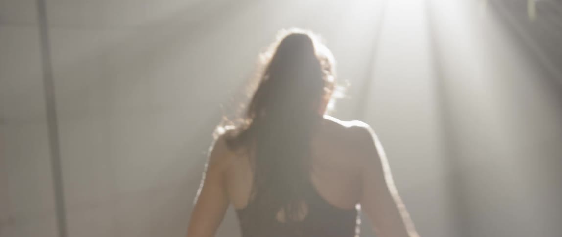A woman in a sports bra stretches and warms up