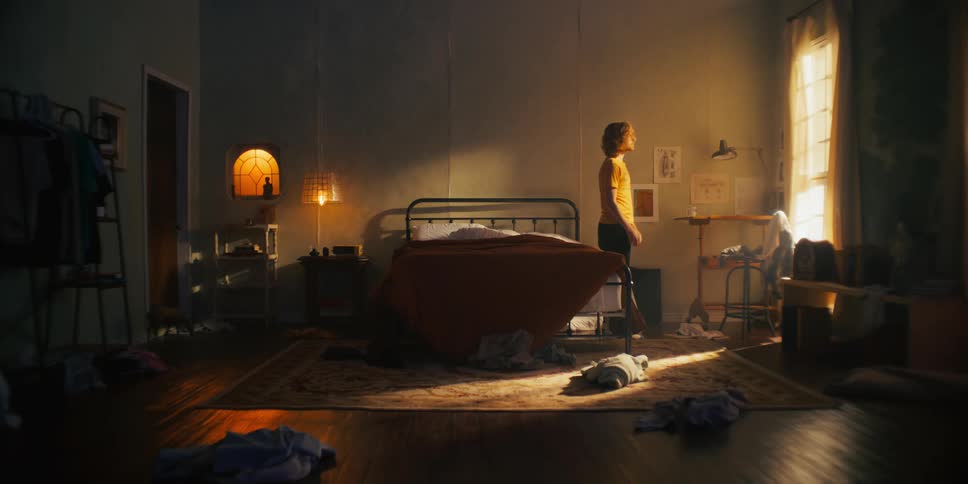 Man lifting bed in messy bedroom
