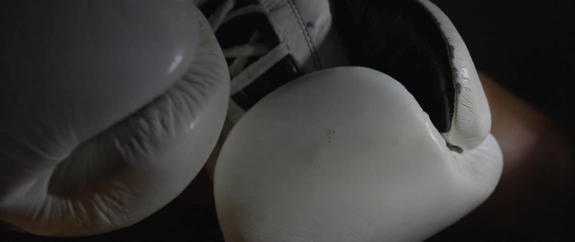 Boxing gloves lay in a dark area