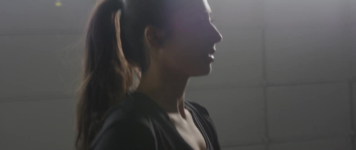 A woman is walking along a long wall
