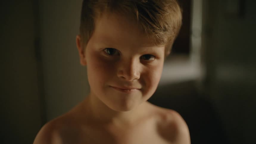 portrait of young boy with a sudden smile on his face
