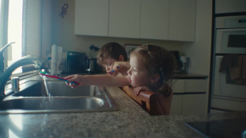 Two children are brushing their teeth